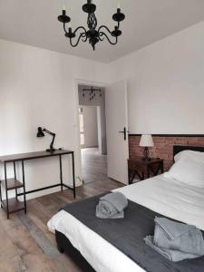 Un dormitorio con una cama, una mesa y una lámpara de araña. en Lafabrik, en Valence