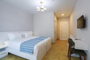a bedroom with a bed and a desk and a television at Emerald Borjomi Hotel in Borjomi