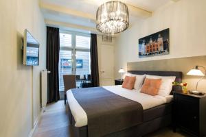 a bedroom with a bed and a window and a chandelier at Grand Canal Boutique Hotel in Amsterdam