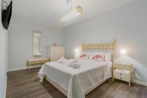 a bedroom with a bed with white sheets and red pillows at Relax Playa San Telmo in Puerto de la Cruz