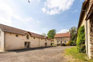 a group of buildings with a driveway and a house at Ferme de Pontaly in Bailly