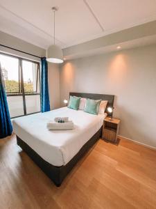 ケープタウンにあるCape Mae Apartment Hotelのベッドルーム1室(青いカーテン付きの大型ベッド1台付)
