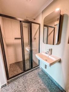 ケープタウンにあるCape Mae Apartment Hotelの洗面台と鏡付きシャワーを備えたバスルーム +45枚の写真