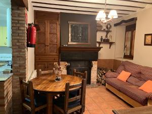 Una sala de estar con una mesa y una chimenea. en Casas Rurales Arcoiris, en Riópar 31 fotos más