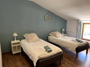 two beds sitting next to each other in a bedroom at Longère bressane. in Domsure +40 photos