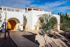 a white house with a courtyard with a tree at L0ST Villa Marrakech in Marrakech