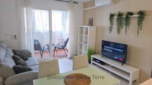 a living room with a couch and a tv at Laguna Beach Paradise - Alojamientos La Torre in Torrox Costa