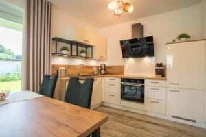 a kitchen with white cabinets and a wooden table at Fewo Lüttje Parl in Hooksiel