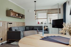 a living room with a table and a couch at Fewo Eiderente Obergeschoss in Hooksiel