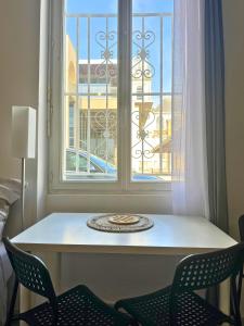 un tavolo e due sedie davanti a una finestra di Mini Nid - Centre - Wifi - Equipé - Cosy a Dax