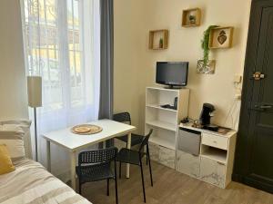 a small room with a small table and a tv at Mini Nid - Centre - Wifi - Equipé - Cosy in Dax
