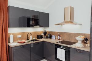eine Küche mit schwarzen Schränken und einer Spüle in der Unterkunft Fewo Haubentaucher Penthouse in Hooksiel