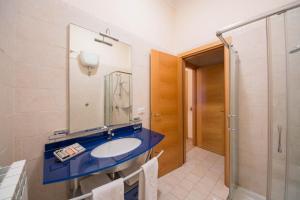 ein Bad mit einem Waschbecken, einem Spiegel und einer Dusche in der Unterkunft La Residenza in Neapel