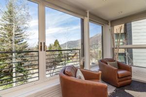 阿斯潘New Listing Renovated 3BR with AC & Pool的带纱窗的门廊，配有两把椅子和大窗户
