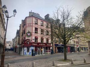 a large building on a street in a city at Studio Titanic Cherbourg Parking in Cherbourg en Cotentin