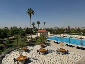 a resort with a pool and tables and chairs at Erbil International Hotel in Erbil
