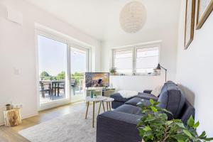a living room with a blue couch and a table at Fewo Hygge Penthouse in Hooksiel