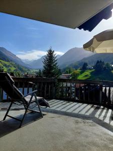 a chair on a balcony with a view of mountains at Charmante Wohnung im Dorfkern in Klosters
