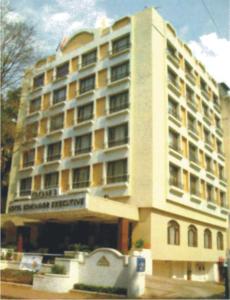 a large building with a hotel in front of it at Hotel Kohinoor Executive in Pune