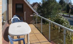 - Balcón con mesa blanca y sillas en Ferienwohnung Klabautermann, en Hooksiel