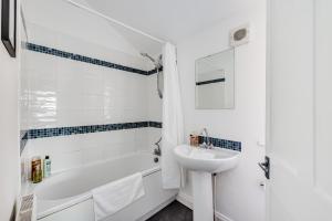 a bathroom with a sink and a tub and a toilet at Charming House in Prime Location - Sleeps 7 - Free Parking, Fast WiFi, Smart TV with Netflix and Virgin TV by Yoko Property in Northampton