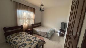 a bedroom with a bed and a tv in it at Pousada Casa da Vó Dita in Ouro Fino