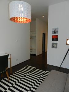 sala de estar con lámpara de araña y alfombra blanca y negra en Art Deco Leipzig, en Leipzig