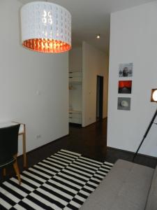 a living room with a chandelier and a black and white rug at Art Deco Leipzig in Leipzig