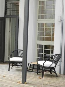 萊比錫的住宿－萊比錫裝飾藝術公寓，门廊上设有两张黑椅子和一张桌子
