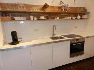 a kitchen with white cabinets and a sink at Art Deco Leipzig in Leipzig