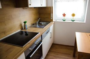 Una pequeña cocina con fregadero y ventana. en Ferienhaus Paula, en Hooksiel