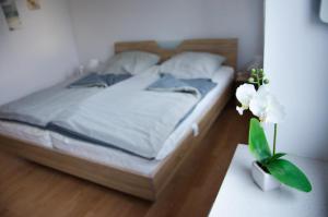 Un dormitorio con una cama y un jarrón de flores sobre una mesa. en Ferienhaus Paula, en Hooksiel