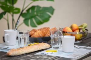 a table with a plate of bread and glasses of water at Gîte Chelona d'Hermann - parking - Chelona'Loc in Braud-et-Saint-Louis +21 photos