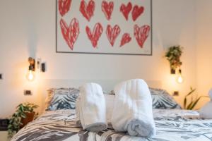 フォルリにある2 Camere 5 ospiti Parcheggio Gratis Recintato, Vicino a Università, Ospedali, Centro, Stazione, Aeroporto, Romagnaの白靴下と心絵のベッド +16枚の写真