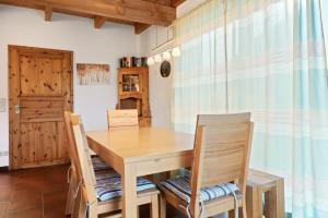 a dining room with a wooden table and chairs at Ferienhaus Fülling in Hooksiel
