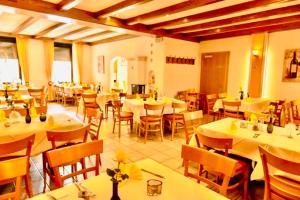 a restaurant with white tables and chairs and tablesearcher at Hotel Pfälzer Hof in Enkenbach-Alsenborn