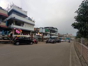 a city street with cars parked in front of buildings at Cental Homestay in Shillong