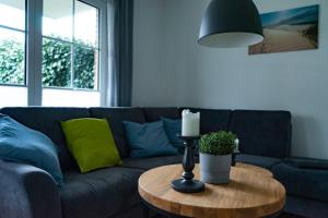 a living room with a couch and a table with a candle at Ferienwohnung Wassmann Hooksiel in Hooksiel