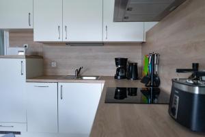 a kitchen with white cabinets and a sink at Ferienwohnung Wassmann Hooksiel in Hooksiel
