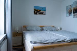 a bedroom with a bed and a picture on the wall at Ferienwohnung Wassmann Hooksiel in Hooksiel +5 photos