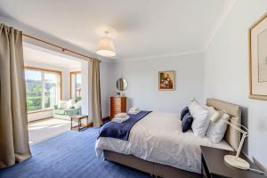 a bedroom with a bed and a desk and a window at Anthony House in Kippford