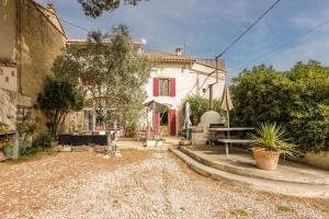 a white house with a red window and a yard at Le Guiguet - Mas provençal avec piscine pour 10 in Vedène