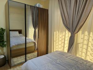 Un dormitorio con una cama y un espejo grande. en Elegant Guest House, en New cairo