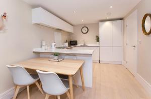 Una cocina y un comedor con mesa y sillas de madera. en Compton Lodge Luxury apartment-Free Parking, en York