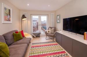 Una sala de estar con un sofá y un televisor de pantalla plana. en Compton Lodge Luxury apartment-Free Parking, en York