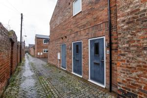 un callejón con puertas azules en un edificio de ladrillo en Compton Lodge Luxury apartment-Free Parking, en York