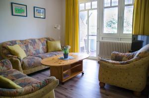 a living room with a couch and two chairs and a table at Ferienwohnung Boje 10 in Schillig