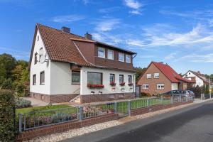 ein weißes Haus mit braunem Dach in der Unterkunft Ferienwohnung Winzenburg in Rehburg-Loccum