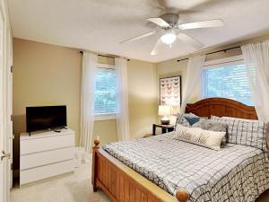 a bedroom with a bed with a ceiling fan and a television at Heavenly Grove in Oakland