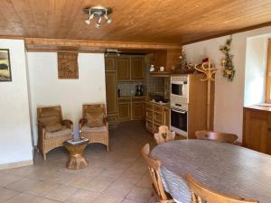 eine Küche mit Tisch und Stühlen in einem Zimmer in der Unterkunft Chalet 18 personnes 8 chambres aux 3 vallees, menuires in Saint-Marcel